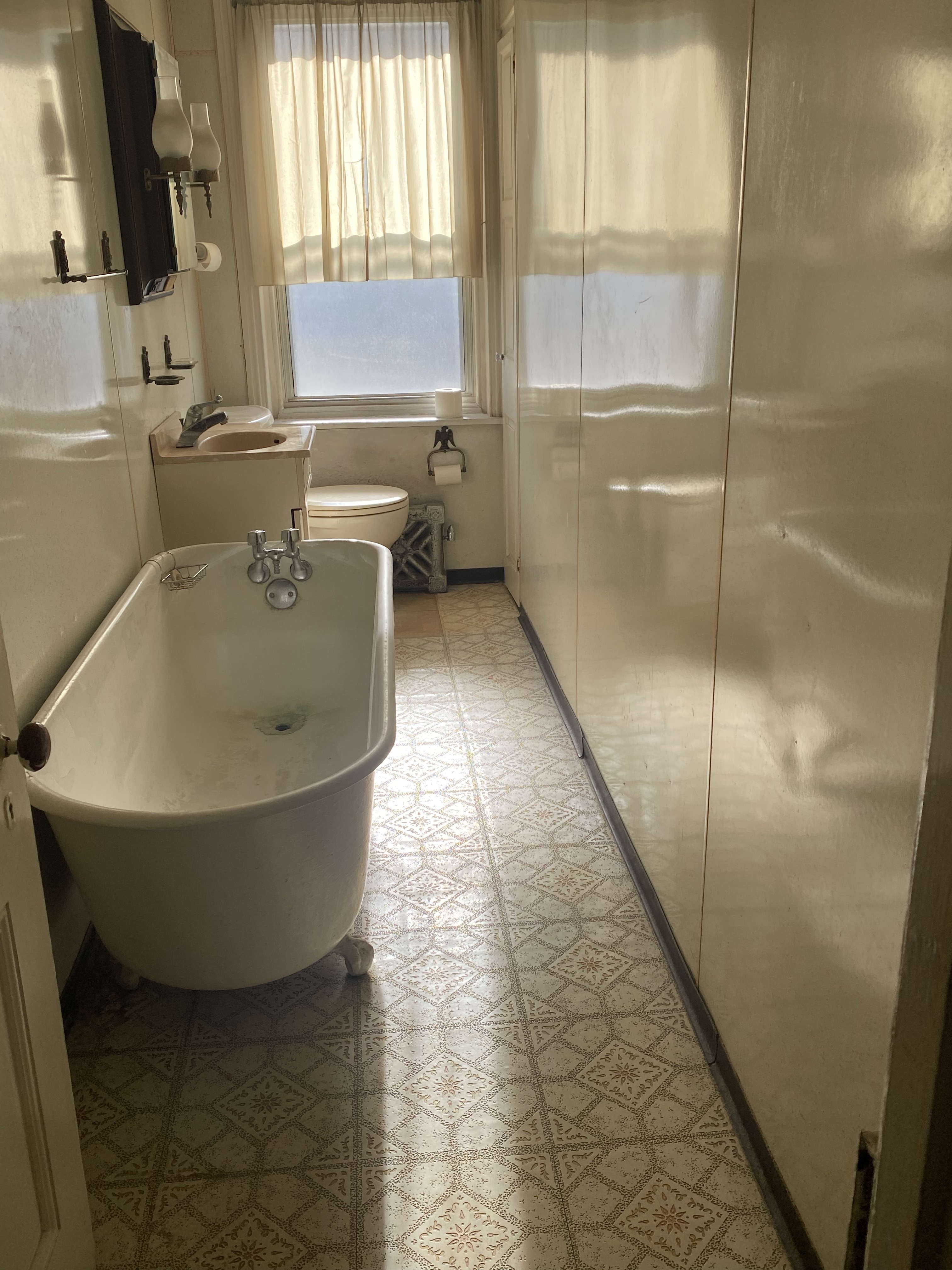 Original E. Columbia Ave bathroom — claw-foot tub, dated tile, original fixtures