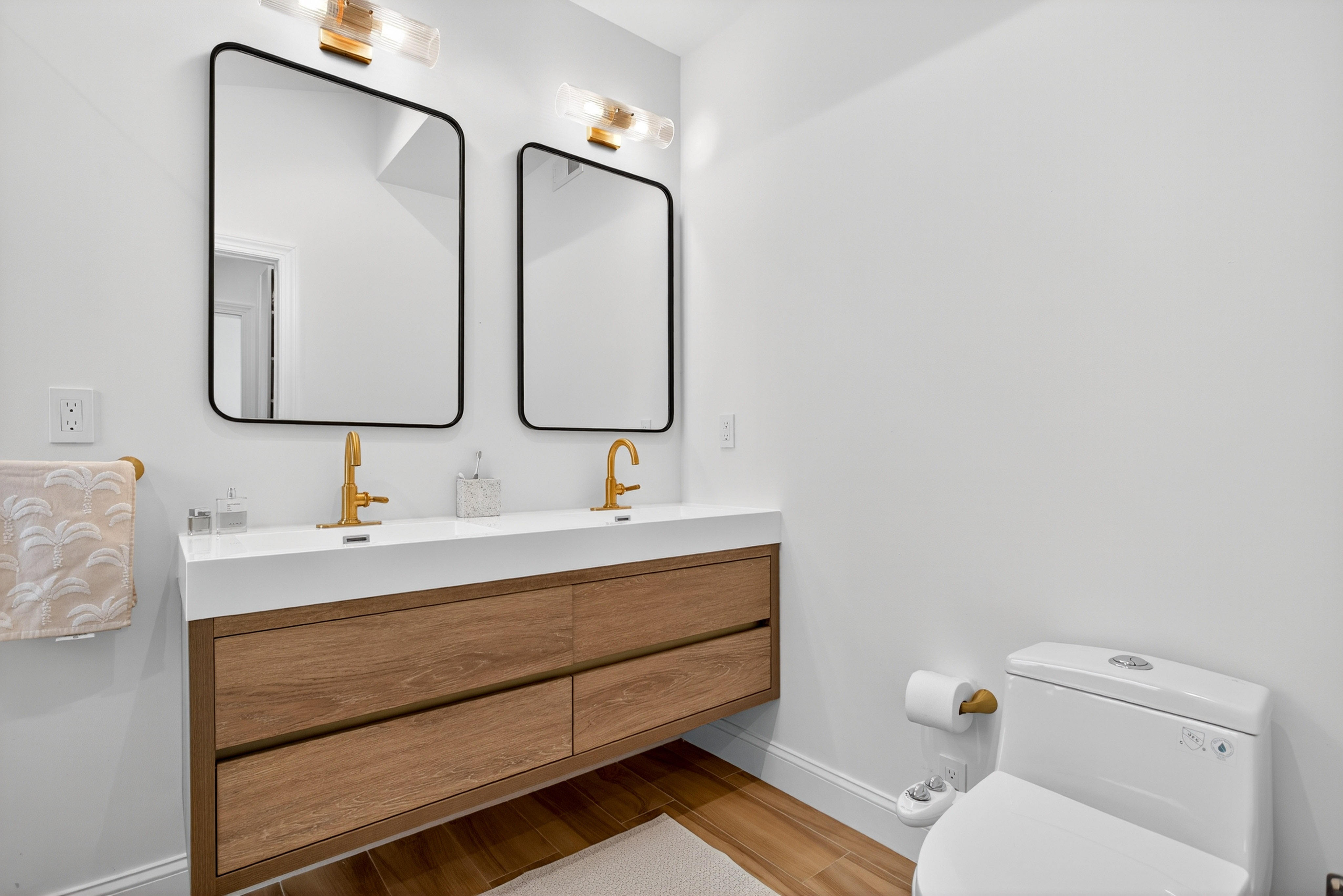 Primary bathroom with double vanity, wood drawers, and black-framed mirrors